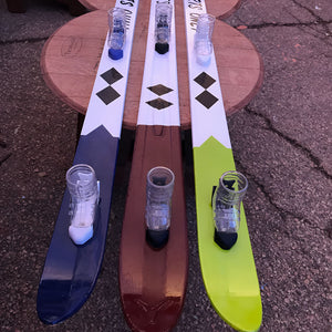 Handpainted double black diamond shot skis on a side table.