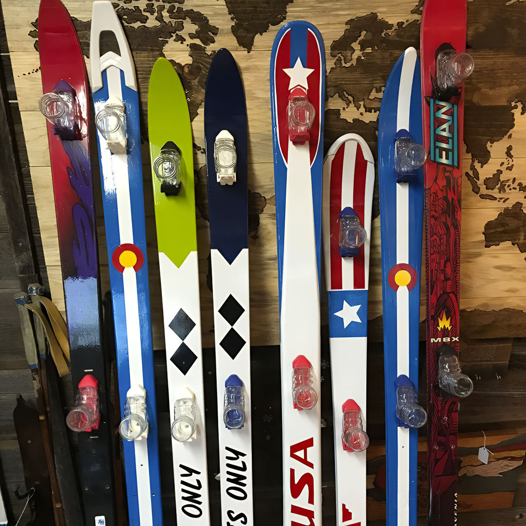 Collection of colorful shot skis with various designs on a wooden surface.