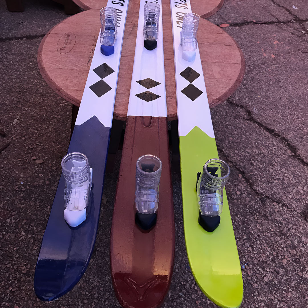 Handpainted double black diamond shot skis on a side table.