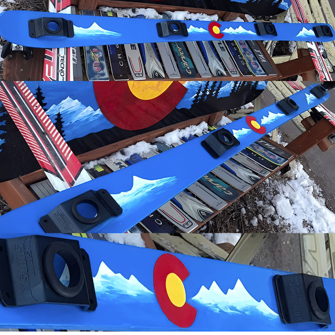 Blue ski with Colorado flag design on a wooden rack.