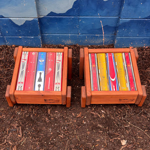 Two colorful ski top ottomans against a blue mountain mural.