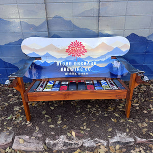 Custom branded Frontier Bench with Blood Orchard Brewing Co. logo and mountain scene on reclaimed snowboard backrest, mixed ski seat, and ski armrests on a wood frame