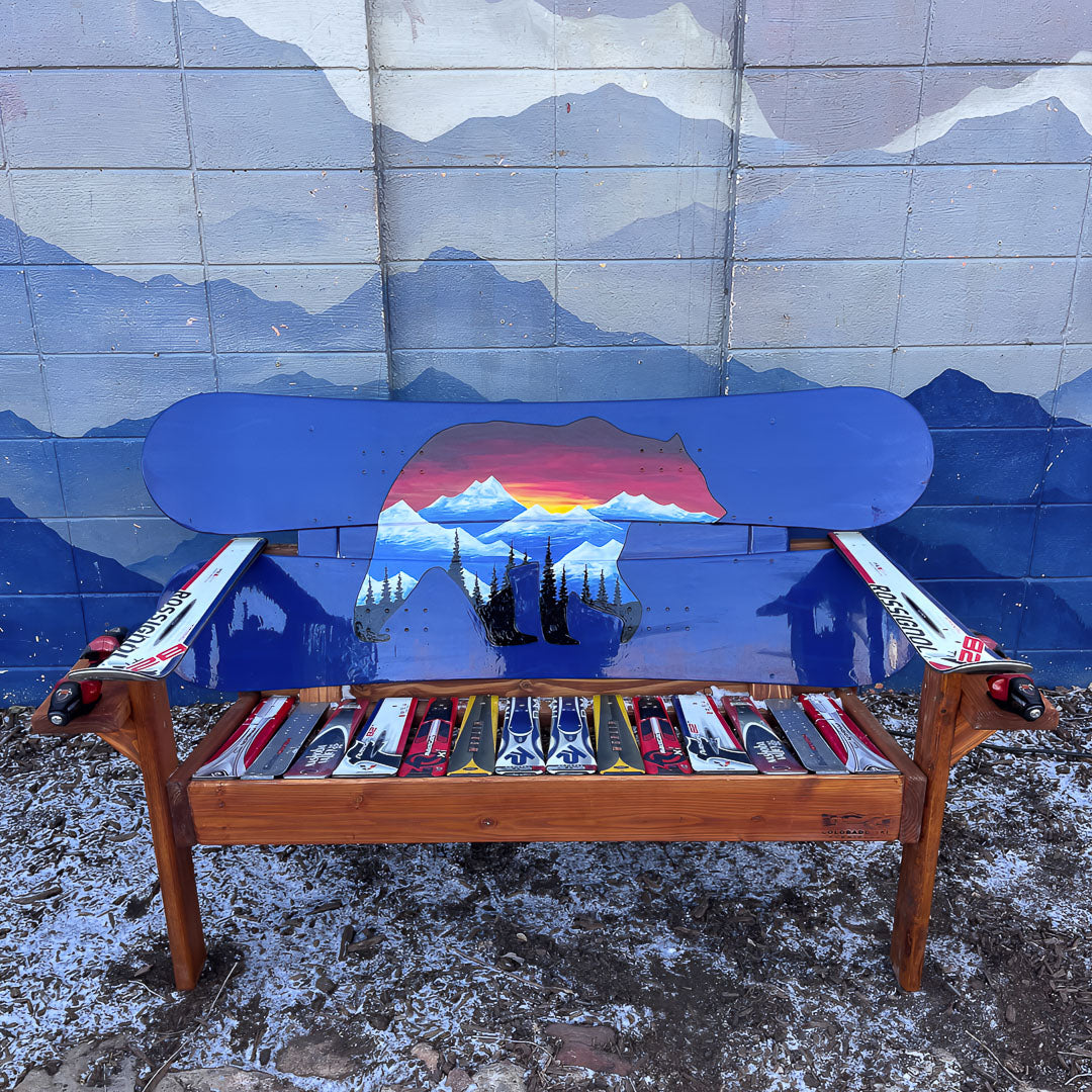 Hand Painted Frontier Bench full size chair build with bear and mountain sunset scene on blue reclaimed snowboard backrest, mixed ski seat, and ski armrests on a wood frame