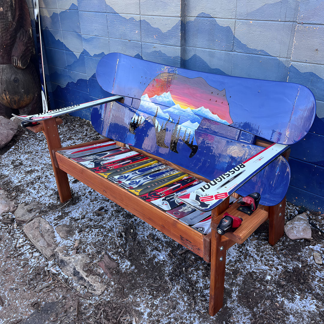 Hand Painted Frontier Bench full size chair build with bear and mountain sunset scene on blue reclaimed snowboard backrest, mixed ski seat, and ski armrests on a wood frame