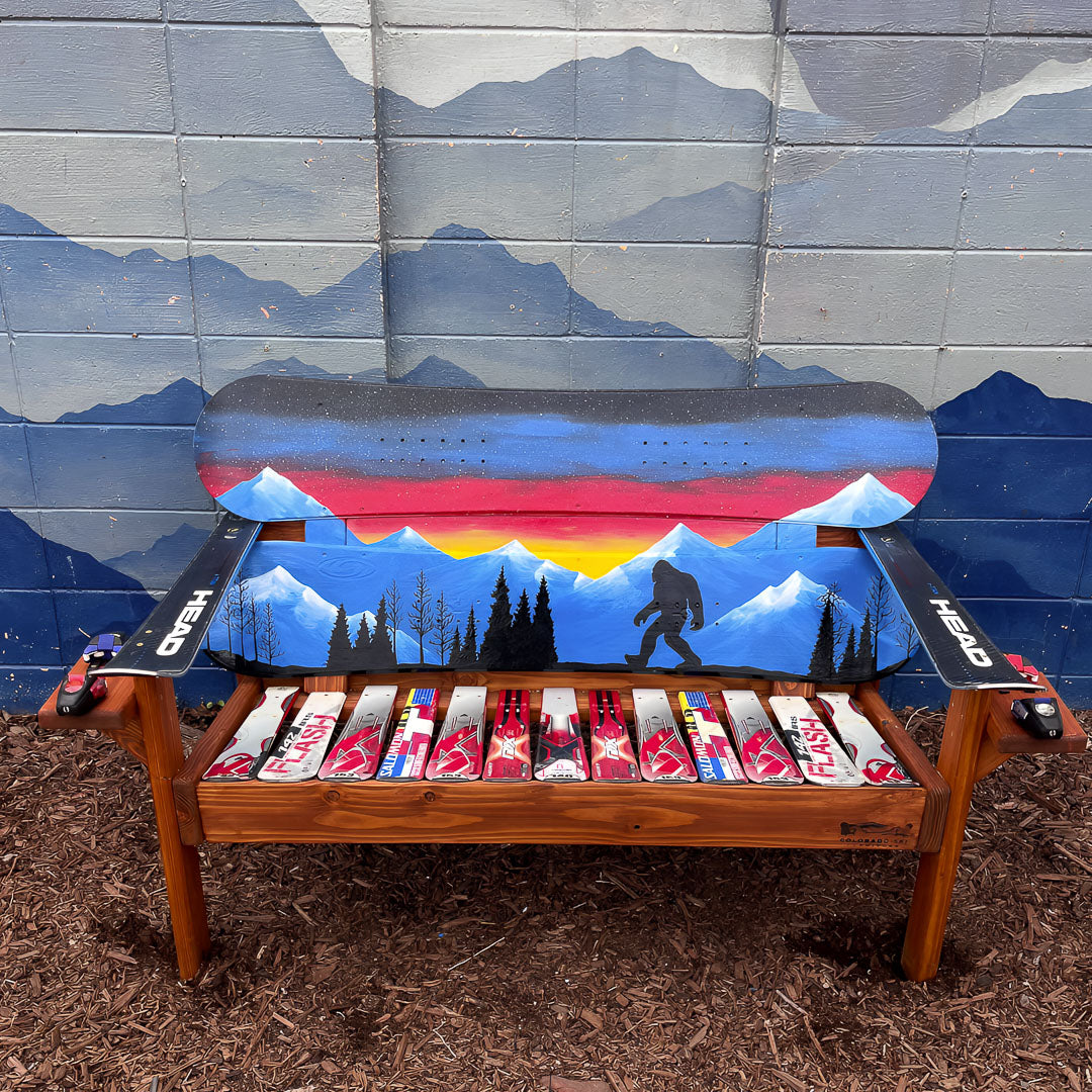 and Painted Frontier Bench full size chair build with Bigfoot and mountain sunset scene on reclaimed snowboard backrest, mixed ski seat, and ski armrests on a wood frame