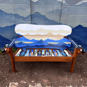 Hand Painted Frontier Bench full size chair build with layered blue mountain range scene on reclaimed snowboard backrest, mixed ski seat, and Dynastar ski armrests on a wood frame